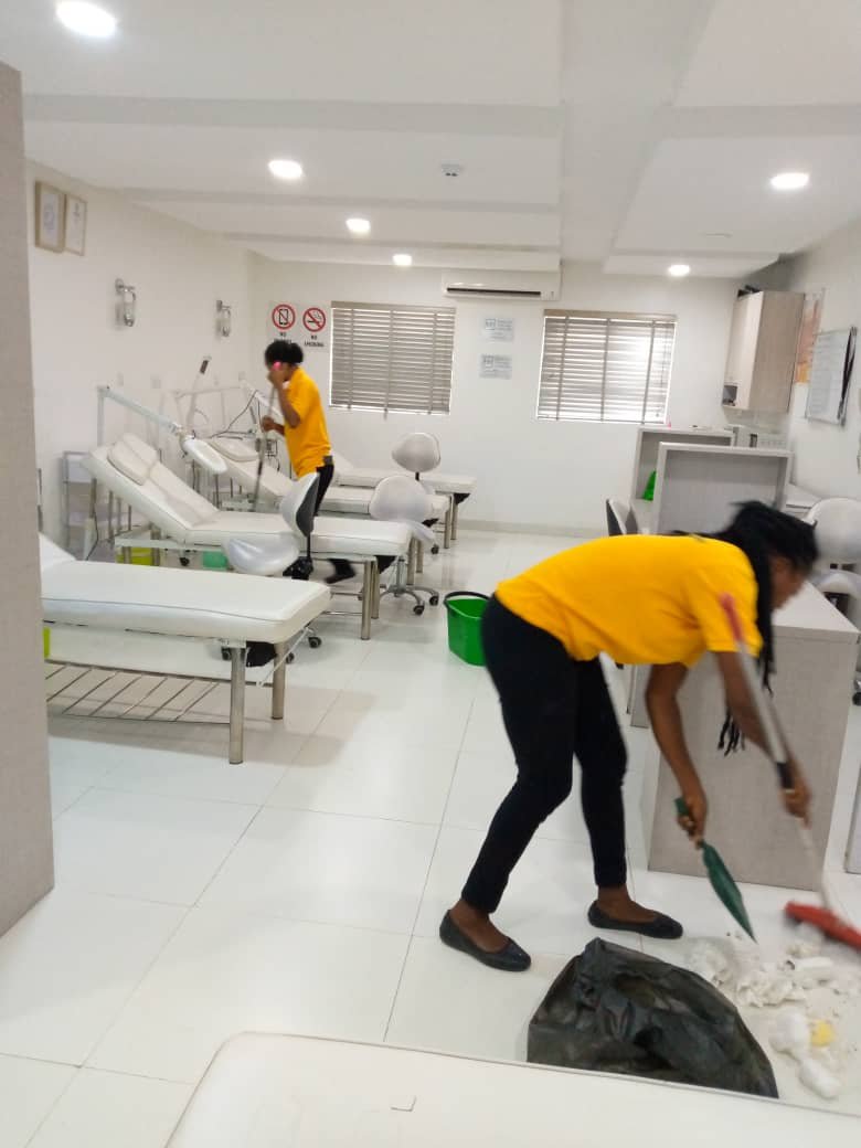 Two Dust and Wipes staff cleaning a medical facility in Abuja