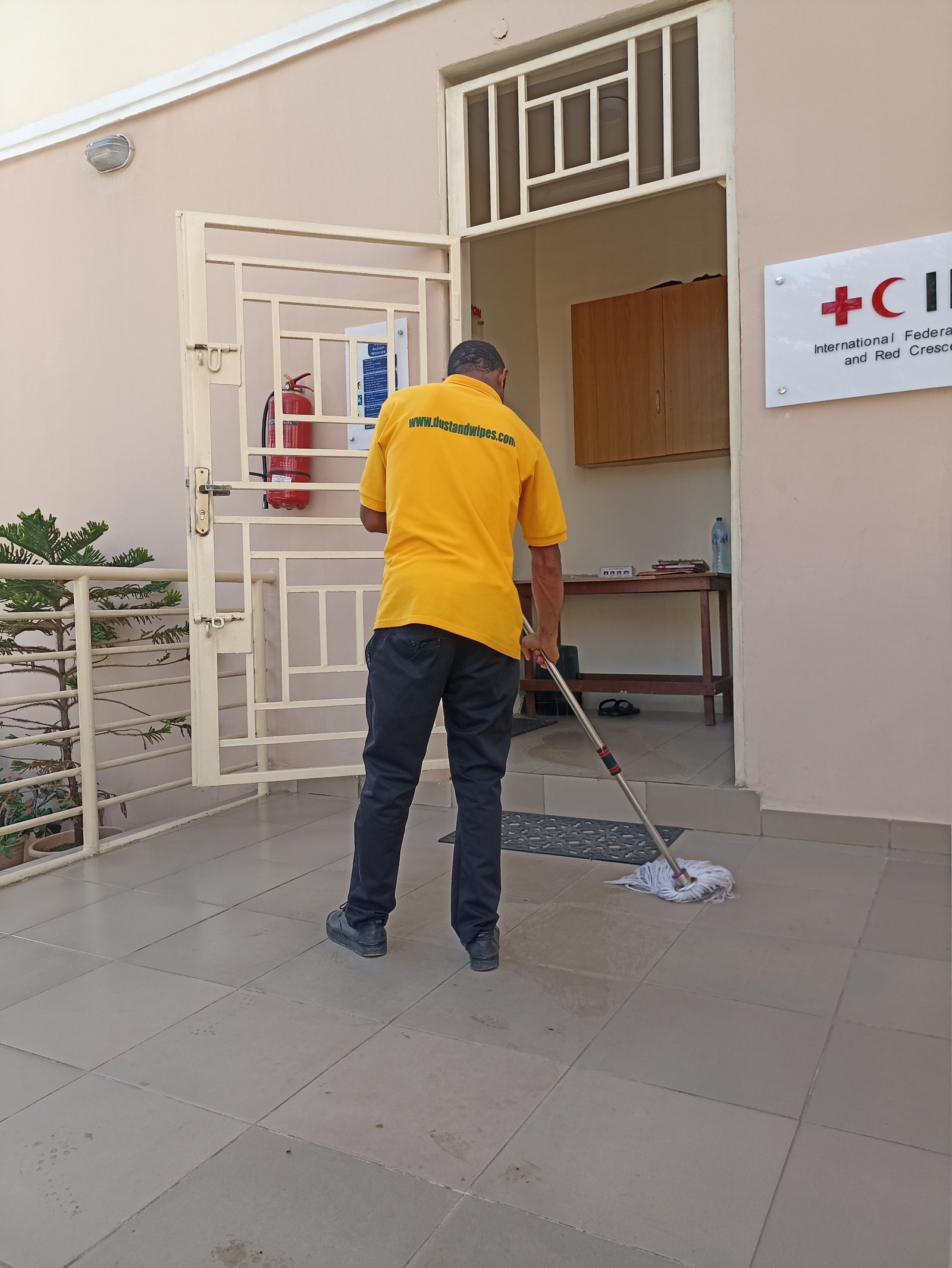 Dust and Wipes staff mopping at International Red Cross office in Abuja